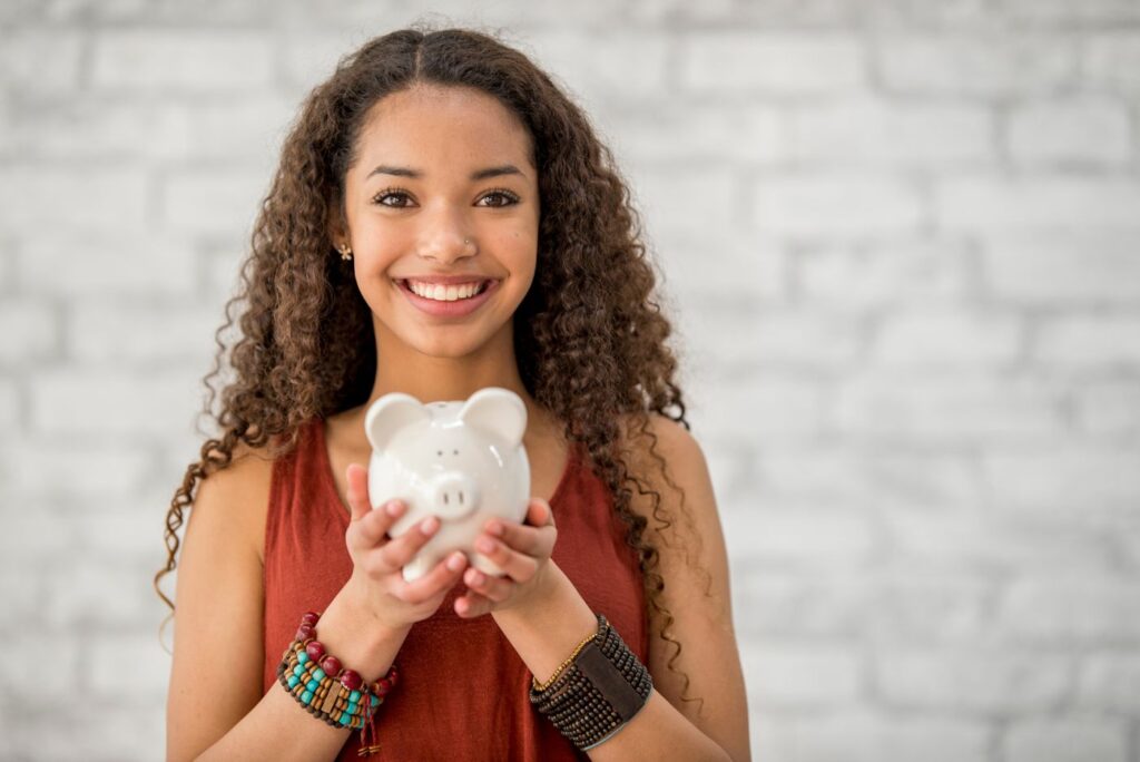 A happy female holding a piggy bank